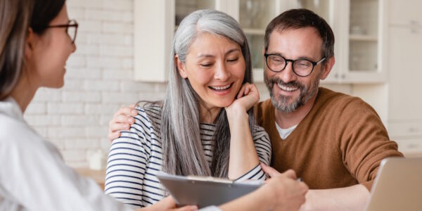 happy couple reviewing debt relief strategies with lawyer