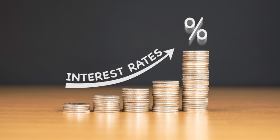 STACKED US QUARTER COINS ON WOODEN TABLE WITH WHITE ILLUSTRATION stacked quarters on a table as a symbol for increasing interest rates