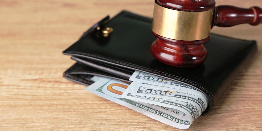 judge’s gavel on wallet with cash judge's gavel on wallet with cash