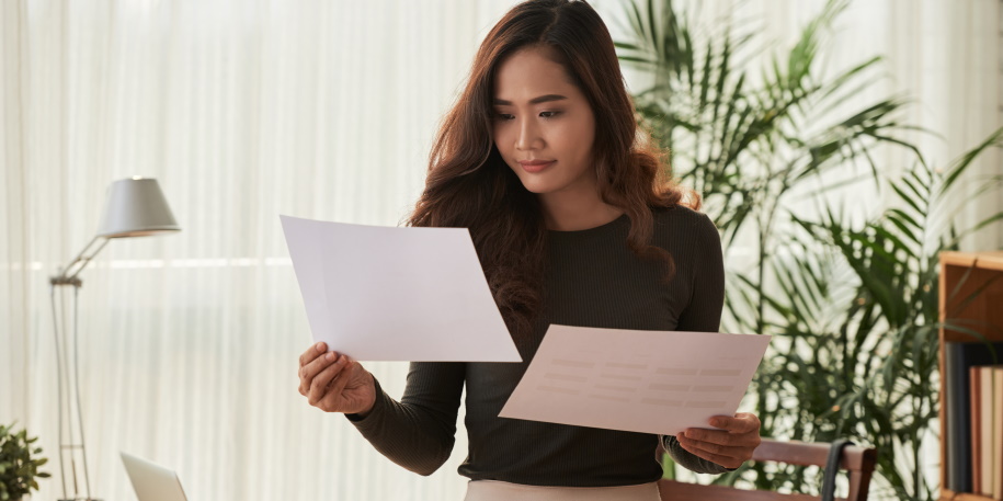 making a decision business woman comparing information in two documents
