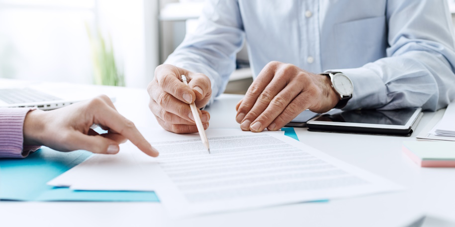 people reviewing a document at a desk people reviewing a document at a desk