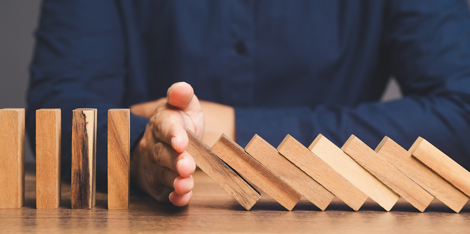 person blocking wooden dominoes with their hand person blocking wooden dominoes with their hand