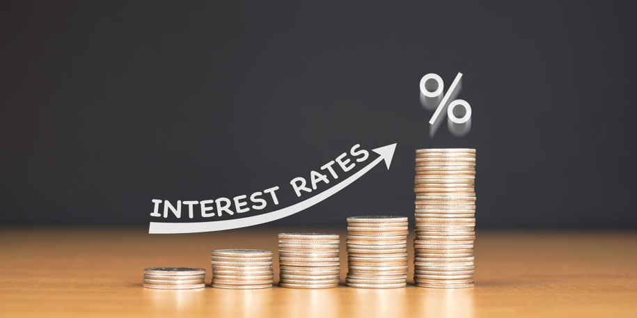 rising interest rates STACKED US QUARTER COINS ON WOODEN TABLE WITH WHITE ILLUSTRATION SHOWS INCREASING OF INTEREST RATES / FINANCIAL CONCEPT
