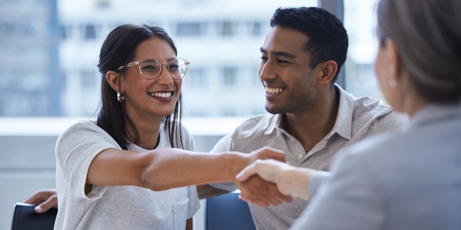 smiling couples shaking hands