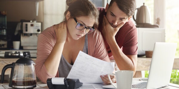 stressed couple looking at bills