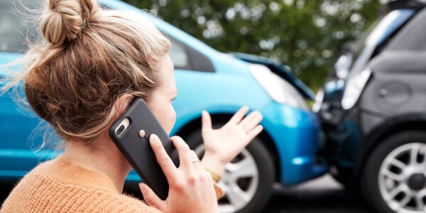 woman on the phone by a car accident