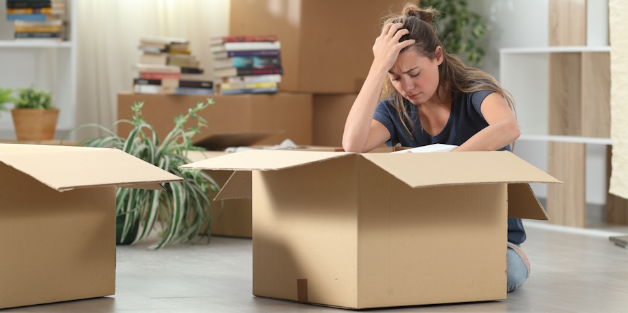 Sad evicted woman moving out packing boxes at home woman sadly packs up her home